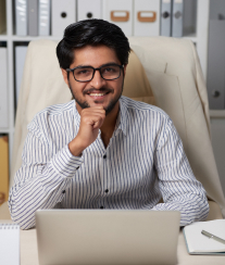 Man smiling at laptop in office